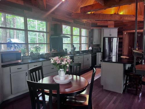 Una cocina con una mesa con un jarrón de flores encima. en Private Pool & Hot Tub at Chalet by Hidden Valley, en Somerset