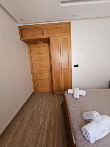 a room with a bed and a wooden door at Luxury Appartement With Fibre Optique, Parking & Marina Swimming Pool 10 Min By Car in Agadir