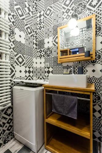une salle de bain avec un lavabo et un miroir sur un mur dans l'établissement Lavie Maison Montmartre Cozy Studio, à Paris