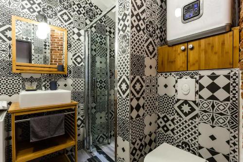La salle de bains est revêtue de carrelage noir et blanc. dans l'établissement Lavie Maison Montmartre Cozy Studio, à Paris