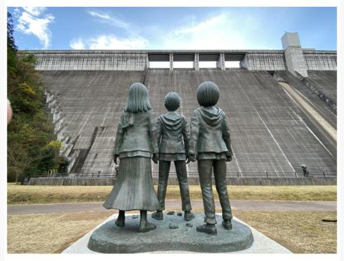 a statue of three children in front of a stadium at 桃の木別荘　Momonoki Villa in Hita