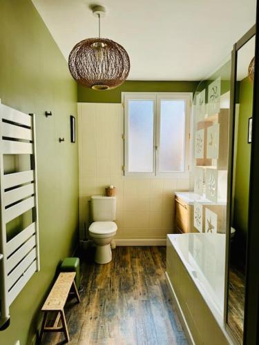 La salle de bains est pourvue de toilettes, d'une fenêtre et d'un lustre. dans l'établissement Le Bon Compromis, à Poitiers