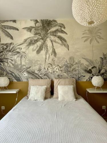 - une chambre avec un grand lit orné d'une fresque murale de palmiers dans l'établissement Le Bon Compromis, à Poitiers