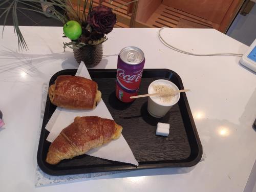 a tray with a soda and a sandwich and a cup of coffee at Locatif gare Lille Europe Souvenir in Lille