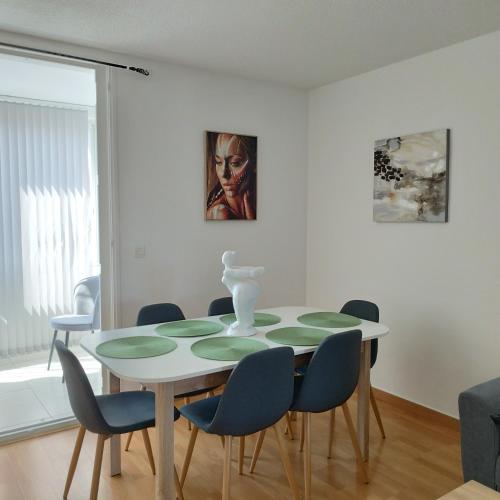 une salle à manger blanche avec une table et des chaises dans l'établissement Au calme et proche de tout !, à Perpignan