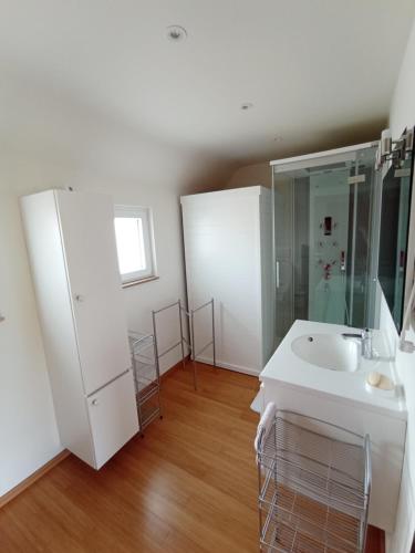 a white bathroom with a sink and a shower at studio in Assesse