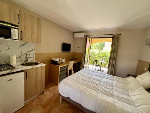 Il comprend une chambre avec un lit et une cuisine avec un évier. dans l'établissement Studio confortable avec piscine, à Sisco