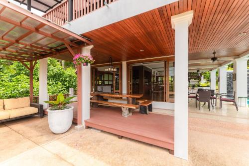 a house with a wooden deck with a table at Guru Resort Chiang Mai in Ban Muang Ha