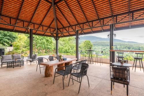 a large patio with tables and chairs and a view at Guru Resort Chiang Mai in Ban Muang Ha