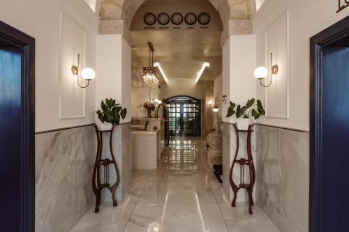 a hallway with two vases with plants in it at Palazzo Castagna Boutique Hotel in Hal Ghaxiak