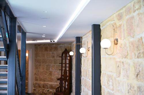 a room with a stone wall and two lights at Palazzo Castagna Boutique Hotel in Hal Ghaxiak