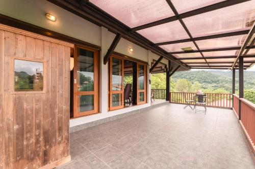an outdoor deck with a wooden door and windows at Guru Resort Chiang Mai in Ban Muang Ha