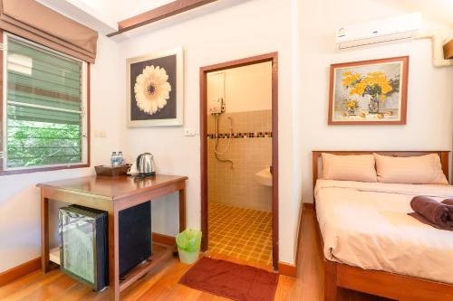 a bedroom with a bed and a desk and a shower at Guru Resort Chiang Mai in Ban Muang Ha