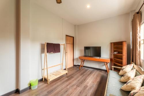 a living room with a couch and a desk at Guru Resort Chiang Mai in Ban Muang Ha