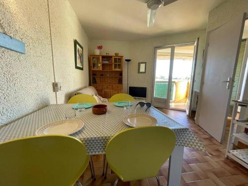 une salle à manger avec une table et des chaises vertes dans l'établissement Appartement 2 pièces 4 couchages ARGELES SUR MER AR320-010, à Argelès-sur-Mer