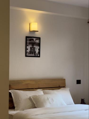 a bed with white pillows and a light above it at Karuna Hotel Patan Kathmandu in Pātan
