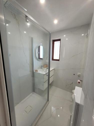une salle de bain blanche avec douche et toilettes dans l'établissement APPARTEMENT VUE MER 200 M DES PLAGES - DJUMBO, à Sainte-Maxime