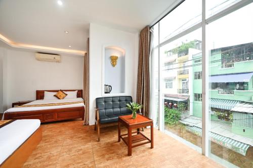 a hotel room with a bed and a large window at Queen Hotel Saigon Airport in Ho Chi Minh City