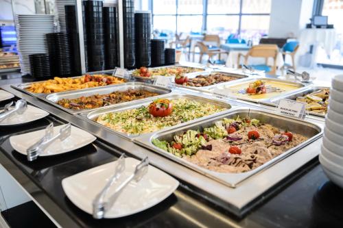 a buffet line with many trays of food at Mirage Beach Spa Hotel in Eforie Nord