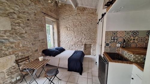 une chambre avec un lit dans un mur de pierre dans l'établissement Mazet au calme avec terrasse, à Nîmes