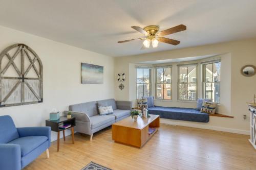 a living room with blue couches and a ceiling fan at Delafield Vacation Rental Near Lakes and Parks! in Delafield