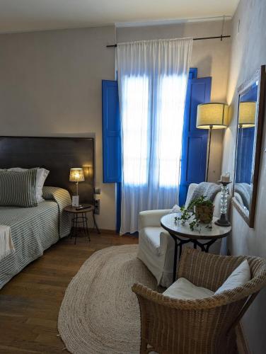 a living room with a couch and a bed and a table at Hostal de la Plaça - Hotel Boutique in Cabrils
