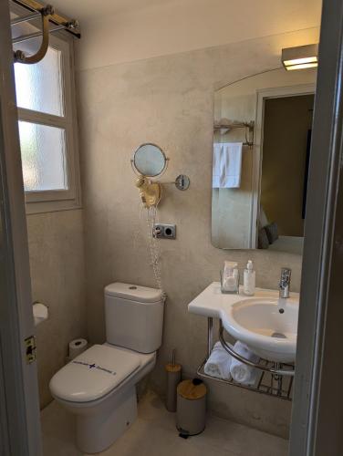 a bathroom with a toilet and a sink at Hostal de la Plaça - Hotel Boutique in Cabrils