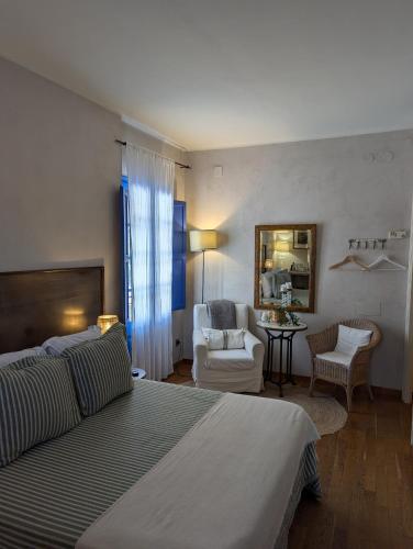 a bedroom with a bed and a living room at Hostal de la Plaça - Hotel Boutique in Cabrils