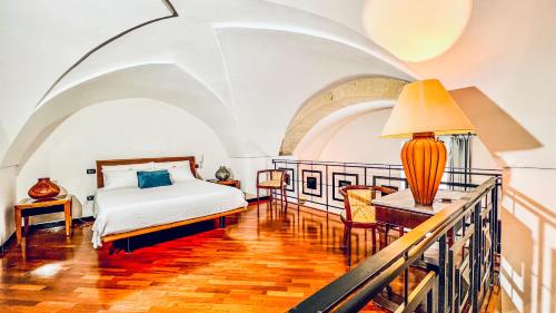 a bedroom with a bed and a table with a lamp at GALA Apartments - Charme Barocco a due passi da Piazza Duomo in Lecce
