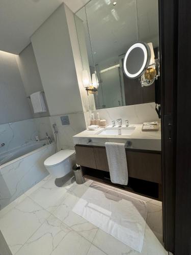 a bathroom with a sink and a mirror and a toilet at Address Beach Resort Residence Bahrain in Rayyā