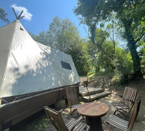 a yurt with chairs and a table and a table and chairs at Au Bonheur Nomade in Livry