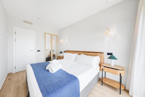 a bedroom with a large white bed and a table at Hotel Ankaa - Adults Only in Porto Cristo