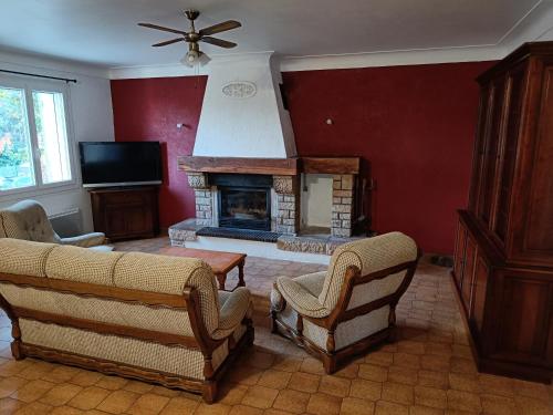 un salon avec deux chaises et une cheminée dans l'établissement Véritable maison de campagne nouvellement rénovée au pied du Lubéron, à Cheval-Blanc