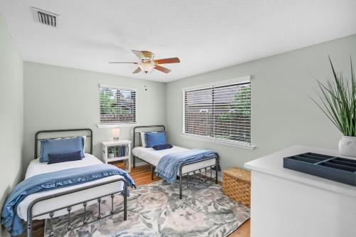 a bedroom with two beds and a ceiling fan at Lakeside Lilypad Wonderland Kayak Grill Firepit in Green Cove Springs