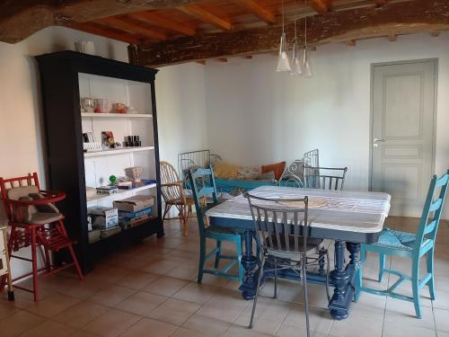 une salle à manger avec une table et des chaises bleues dans l'établissement Maison Paradis Pr Enfants, à Troncens
