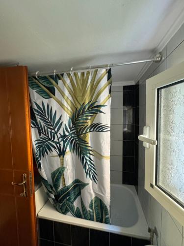 ネア・ペラモスにあるChristinas Deluxe Apartmentのバスルーム(シャワーカーテン付きのバスタブ付)
