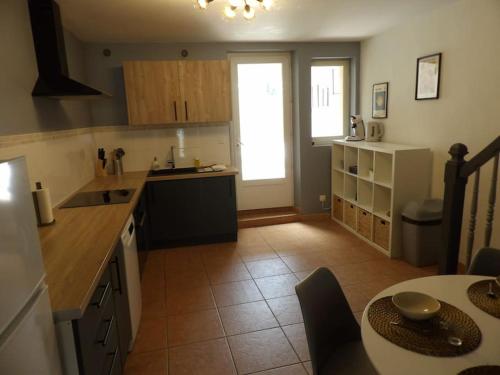 une cuisine avec une table et un comptoir dans l'établissement Cosy House au coeur des Landes, à Villeneuve-de-Marsan