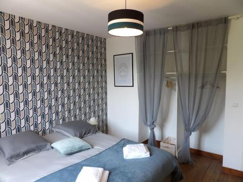 une chambre avec un grand lit avec une couverture bleue dans l'établissement Cosy House au coeur des Landes, à Villeneuve-de-Marsan