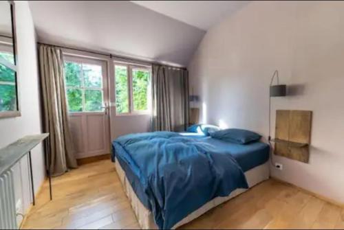 une chambre avec un lit bleu et une fenêtre dans l'établissement Gîte de Charme 4 PERSONNES ZOO Beauval, Châteaux de la Loire, à Billy