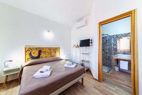 a bedroom with a bed and a bathroom with a mirror at BeB MaLú in Torpè