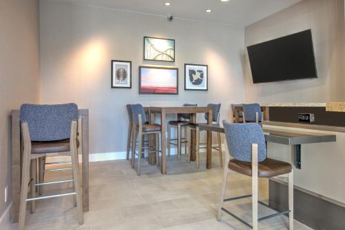 a bar with chairs and a television on a wall at Hilton Garden Inn Dallas Arlington in Arlington