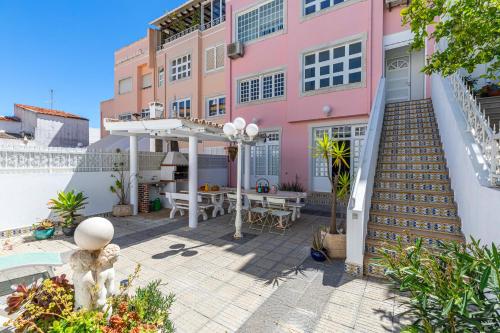 a pink house with a patio and a table at Casa Pink Flamingo Spacious Town Centre Villa in Tavira