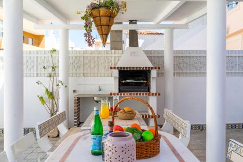 a table with a basket of fruit on a porch at Casa Pink Flamingo Spacious Town Centre Villa in Tavira
