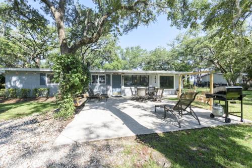 un patio avec des chaises et un barbecue et une maison dans l'établissement Birdsong Cottage, à Freeport