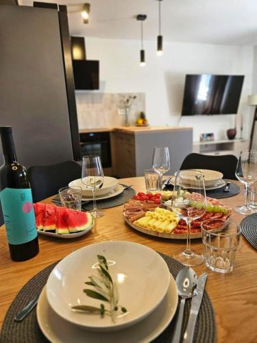 a table with plates of food and a bottle of wine at Roberta in Sali