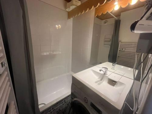 une salle de bain avec un lavabo, un miroir et une baignoire dans l'établissement Appartement skis aux pieds BETELGEUSE, à Risoul