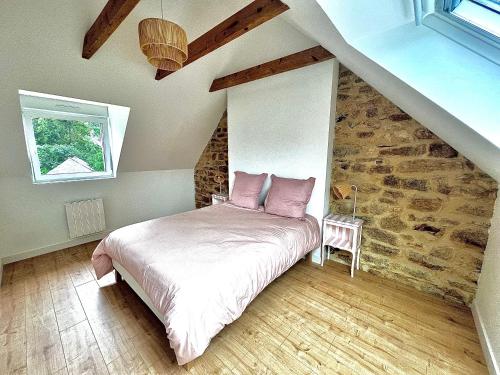 une chambre avec un lit avec des oreillers roses dessus dans l'établissement La longère de Ty Pors, à Combrit