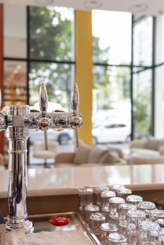 a kitchen counter with a water faucet and glasses at Hôtel Kyriad Prestige Paris Asnieres in Asnières-sur-Seine