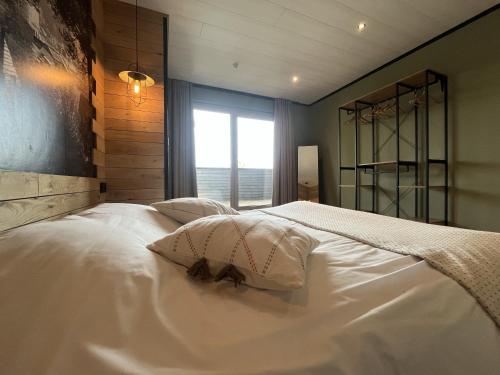 a large white bed with two pillows and a window at Lu T Chene in Opont
