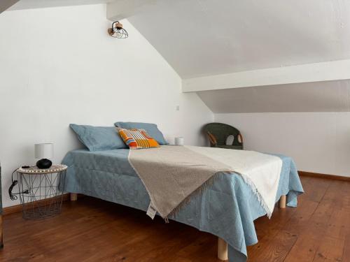 a bedroom with a bed with a blue blanket at Maison 4 personnes avec piscine in Bourriot-Bergonce